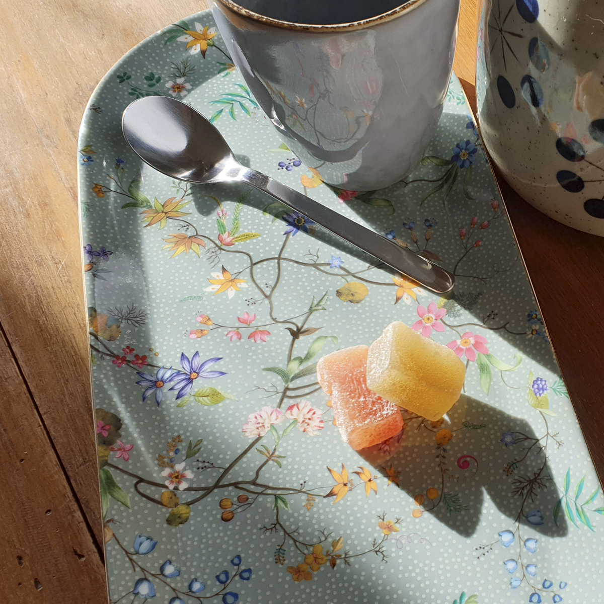 Plat à cake en porcelaine véritable, motif floral, fond bleu-vert.